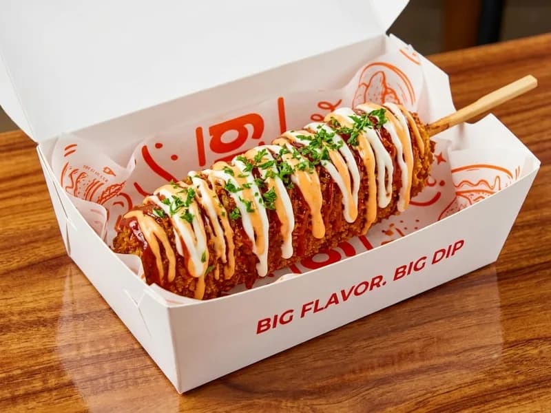 A BigDip corn dog finished with sauces